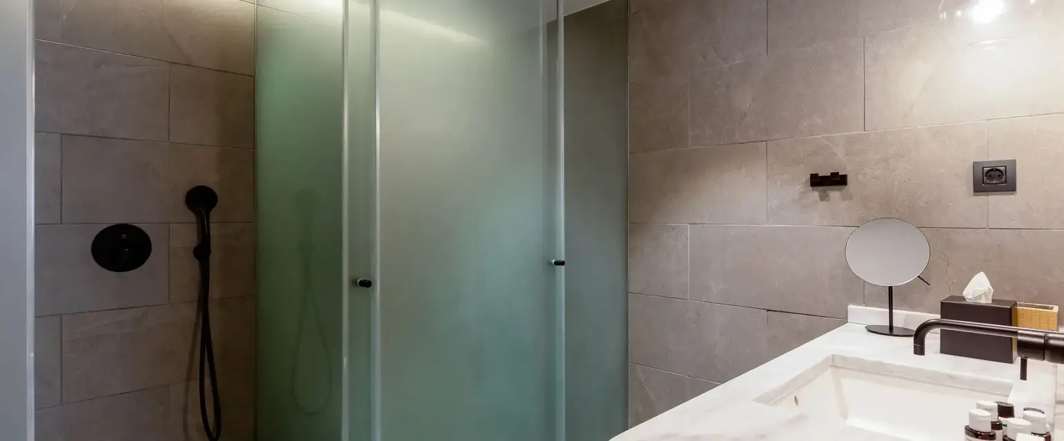 a bathroom with a glass shower and sink