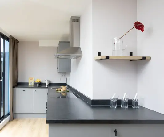 a kitchen with a black countertop and a glass pitcher