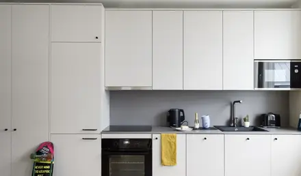 a kitchen with white cabinets and a black stove