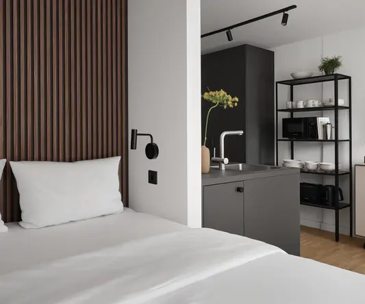 a bed with white sheets and a black shelf