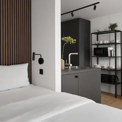 a bed with white sheets and a black shelf