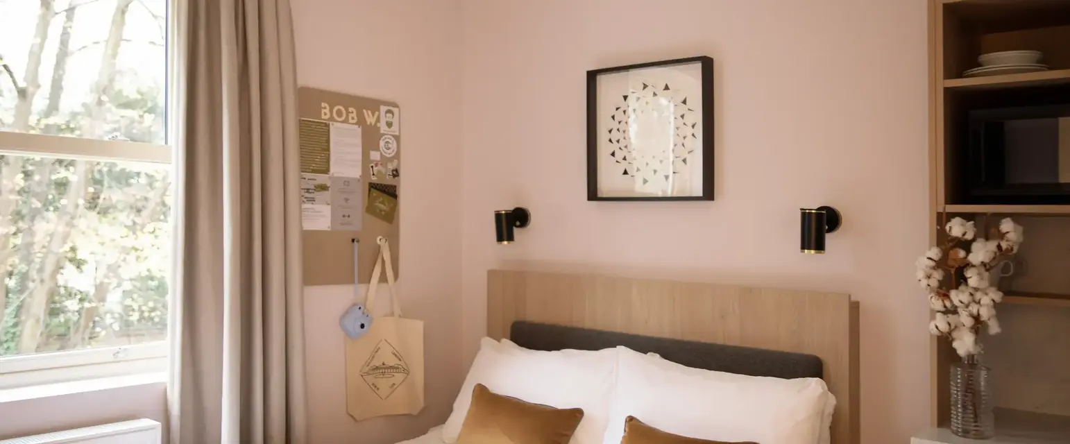 a bed with pillows and a picture on the wall