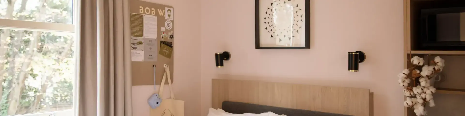 a bed with pillows and a picture on the wall