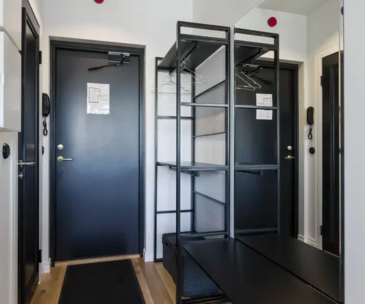 a hallway with black shelves and a black bench