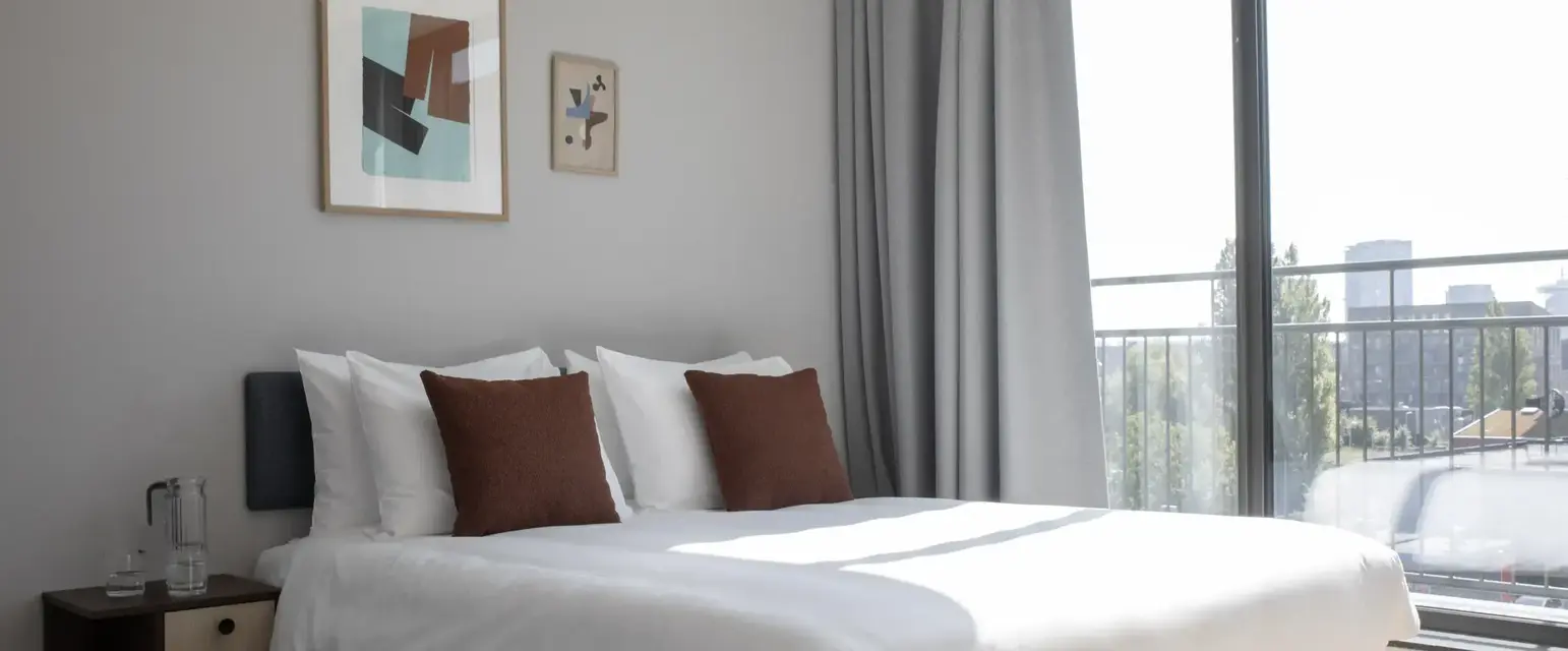 a bed with pillows and a window