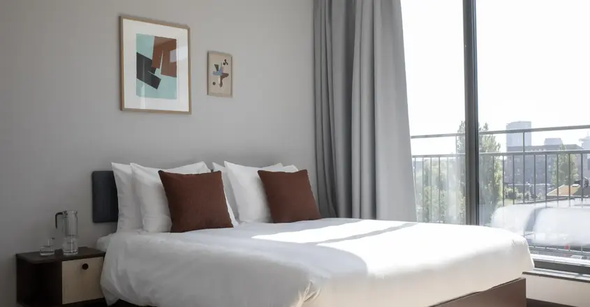 a bed with pillows and a window