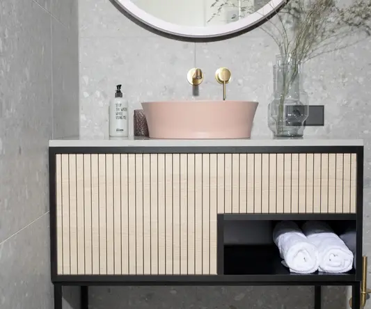 a bathroom sink with a round mirror and a white towel
