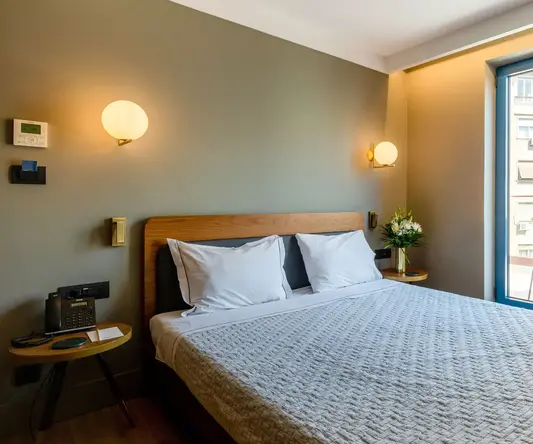 a bed with a glass door and a table with flowers