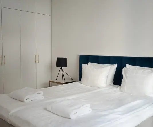 a bed with white sheets and towels on it