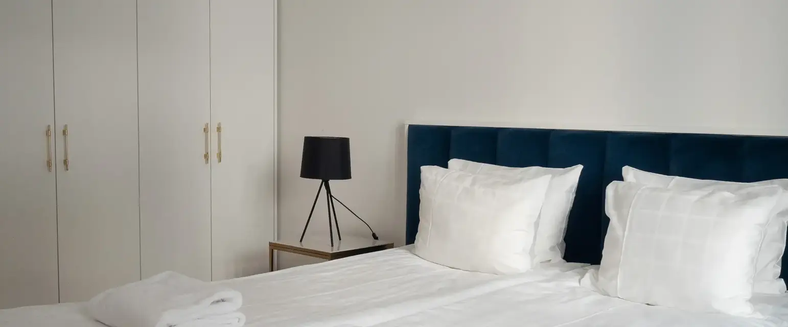 a bed with white sheets and towels on it