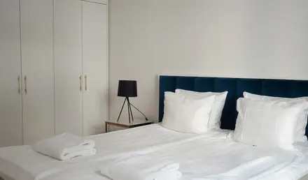 a bed with white sheets and towels on it