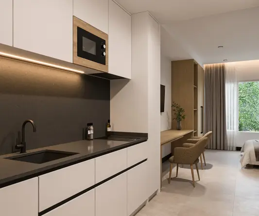 a kitchen with a microwave and a bed