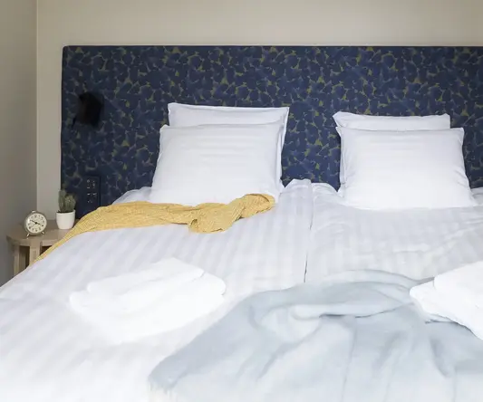 a bed with white sheets and blankets