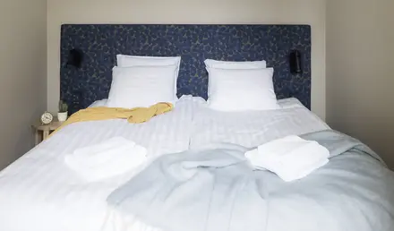 a bed with white sheets and blankets