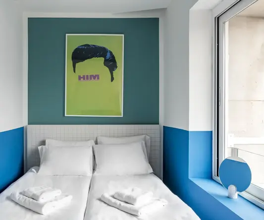 a bed with white sheets and towels on it