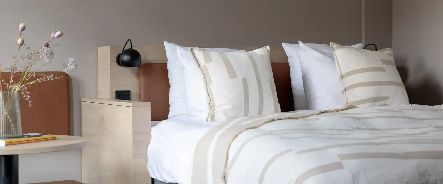 a bed with pillows and a lamp