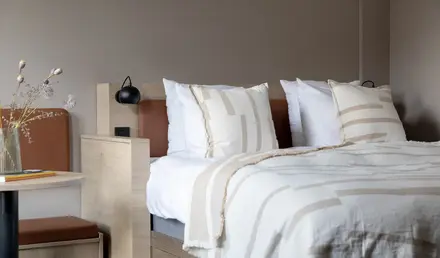 a bed with pillows and a lamp