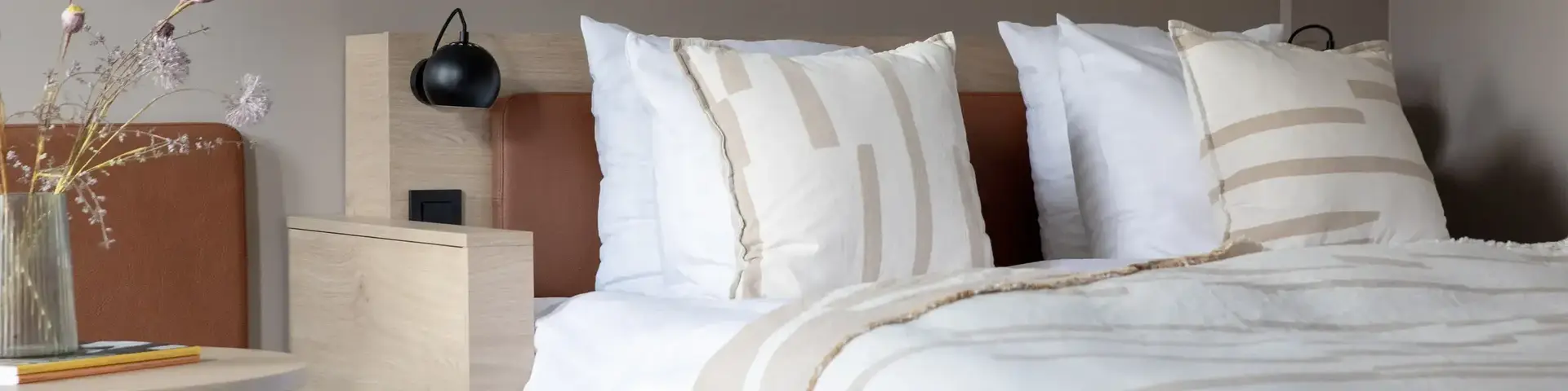 a bed with pillows and a lamp