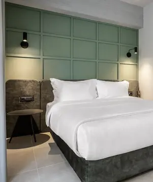 a bed with white sheets and a table