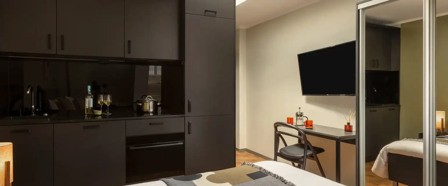 a room with a bed and a desk and a television