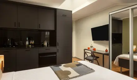 a room with a bed and a desk and a television