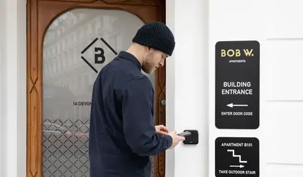 a man using a phone to enter a building