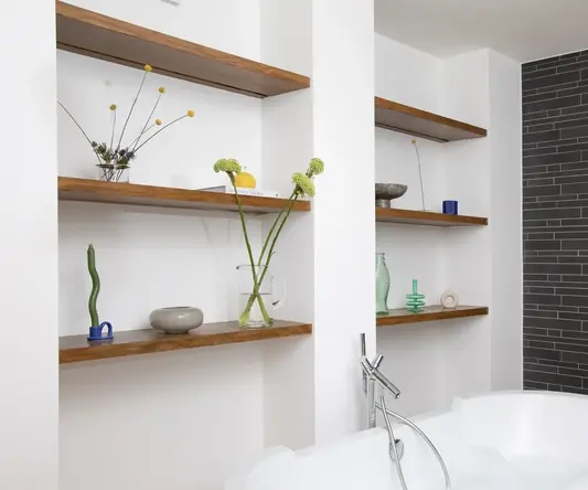 a bathtub and shelves in a bathroom