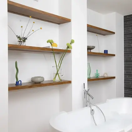 a bathtub and shelves in a bathroom