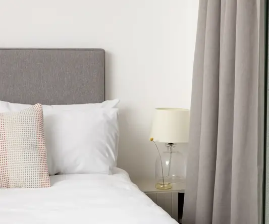 a bed with a lamp next to it