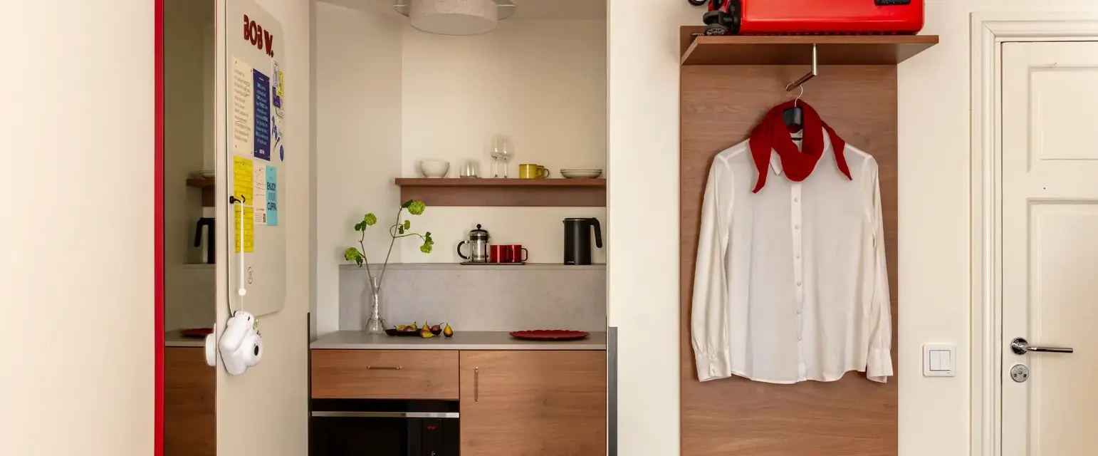 a room with a red suitcase and a white shirt