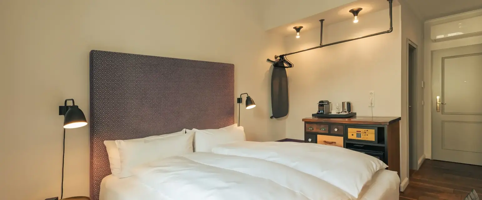 a bed with white sheets and a brown headboard