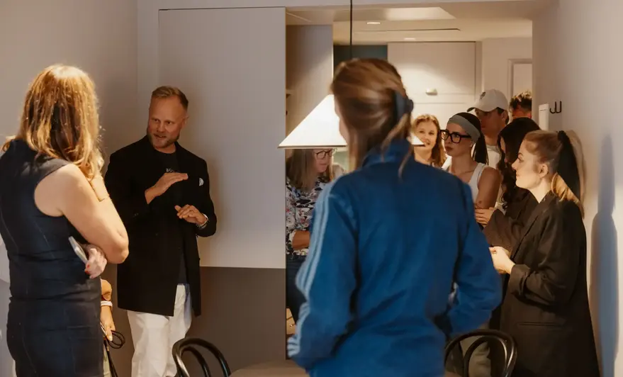a group of people standing around a table