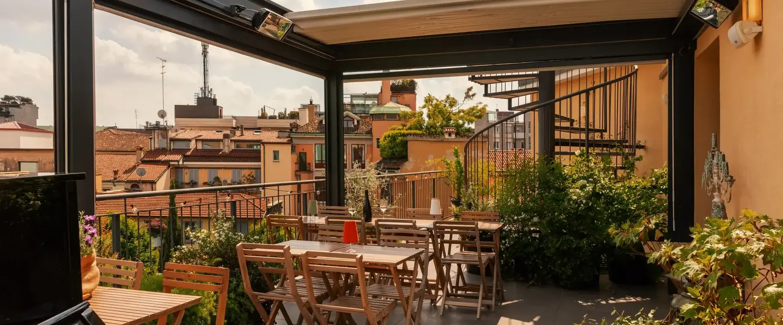 a patio with chairs and tables on a rooftop