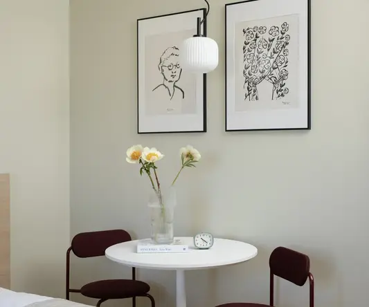 a table with a vase of flowers and chairs