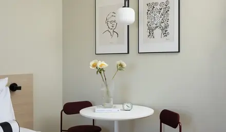 a table with a vase of flowers and chairs