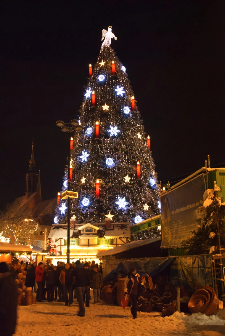 Dortmund's giant Christmas tree with red candles and an angel on top, above the market at night