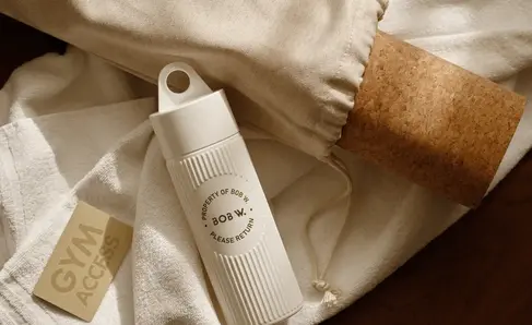 a white bottle next to a white towel