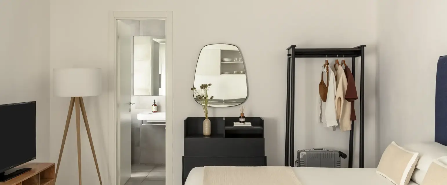 a room with a mirror and a bed