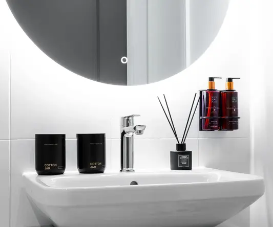 a bathroom sink with a round mirror