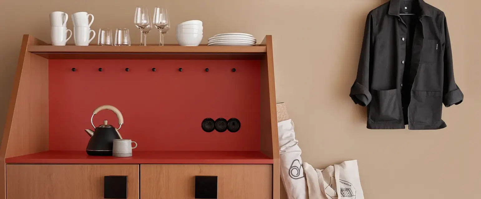 a kitchen with a black coat on a hook