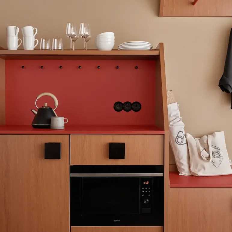 a kitchen with a black coat on a hook