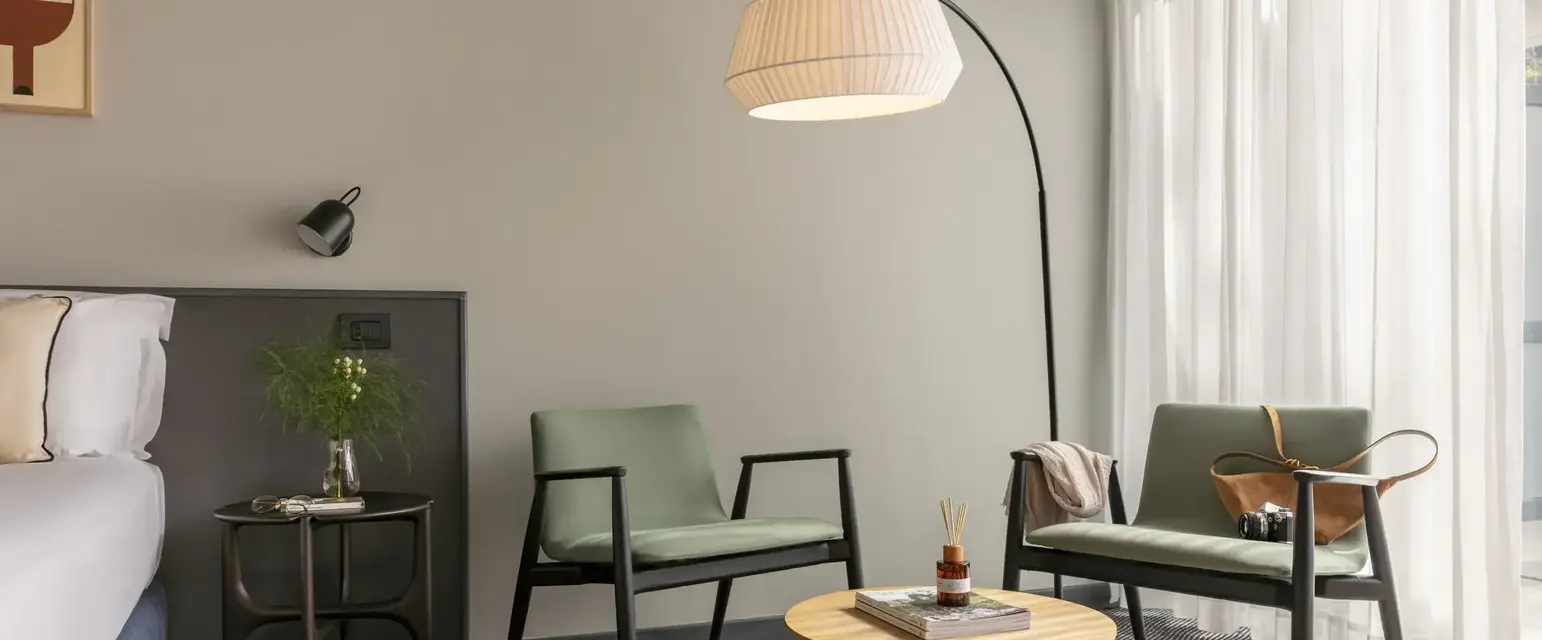 a room with a lamp and chairs