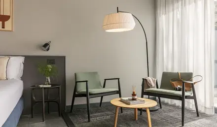 a room with a lamp and chairs