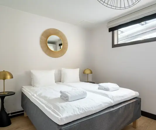 a bed with white sheets and pillows