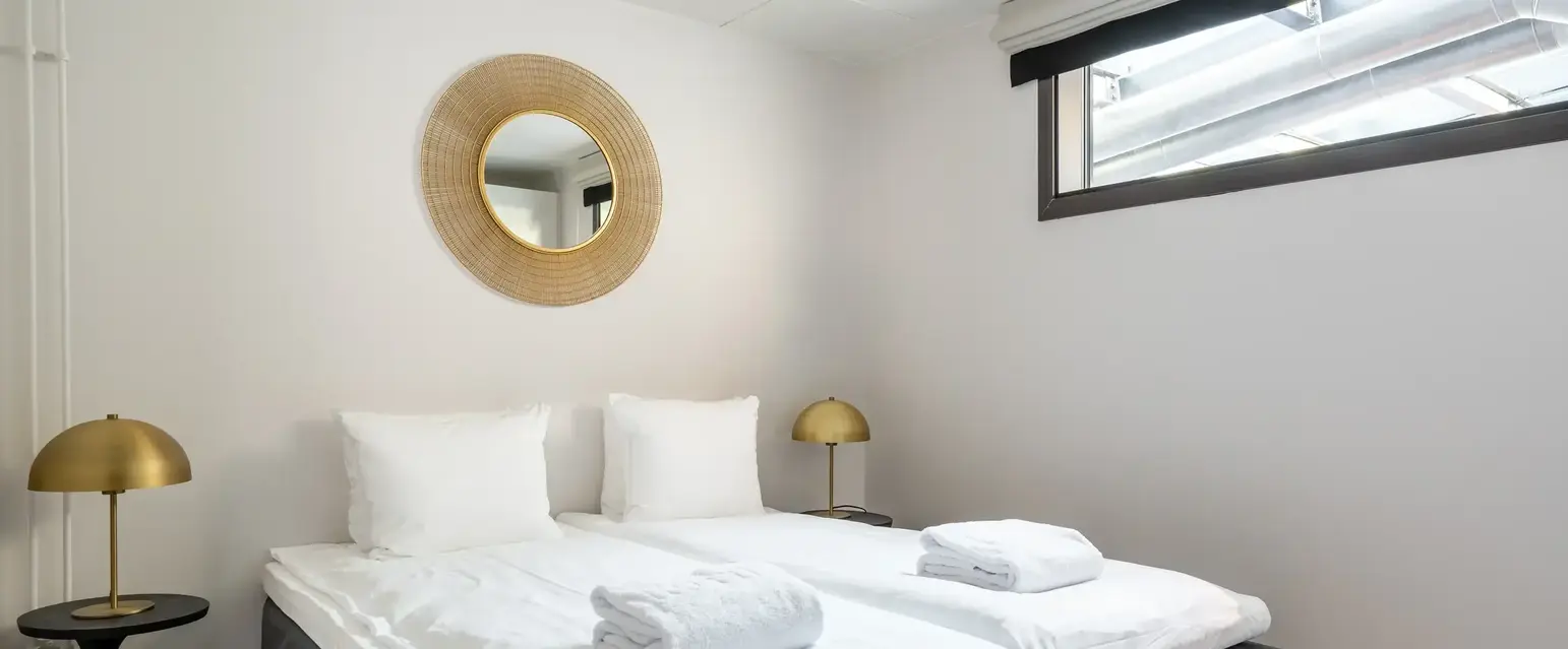 a bed with white sheets and pillows