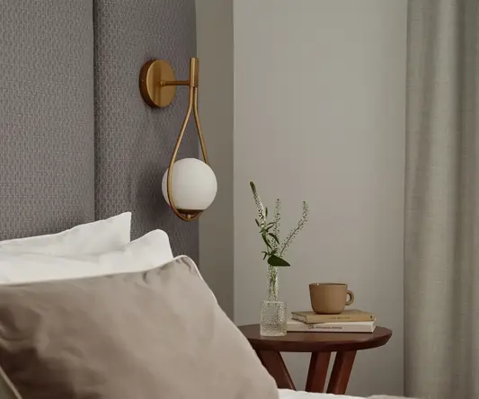 a bed with pillows and a cup of coffee on a table