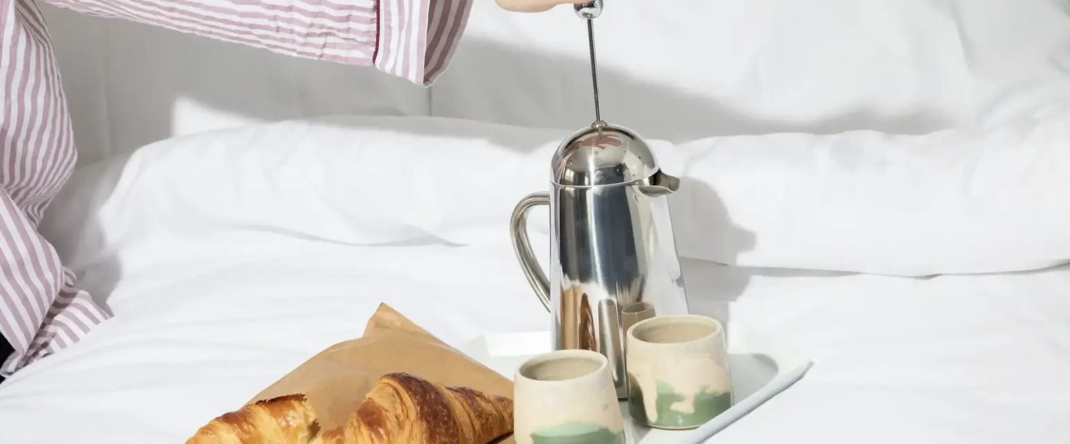 croissants and coffee on a bed