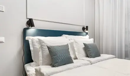 a bed with white sheets and pillows