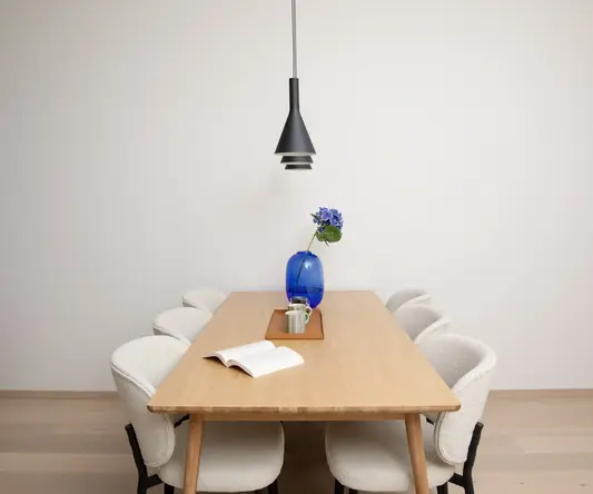 a table with chairs and a vase of flowers