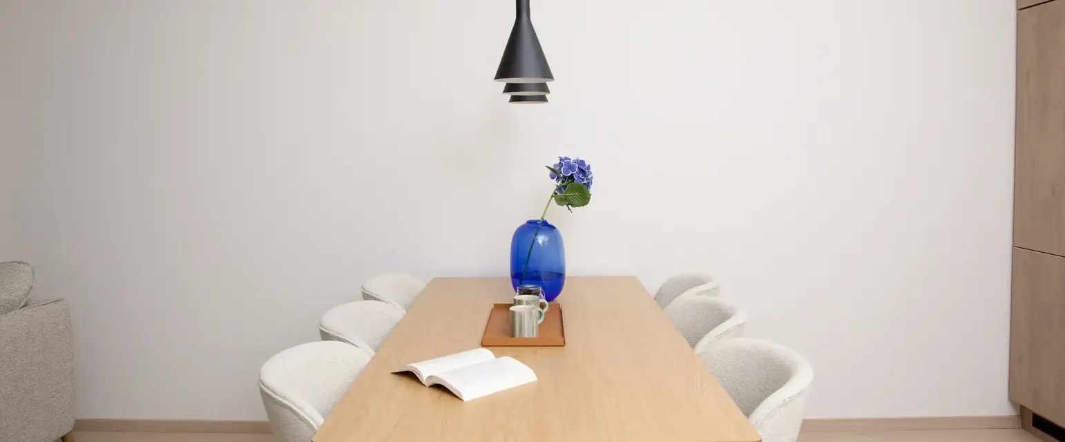 a table with chairs and a vase of flowers